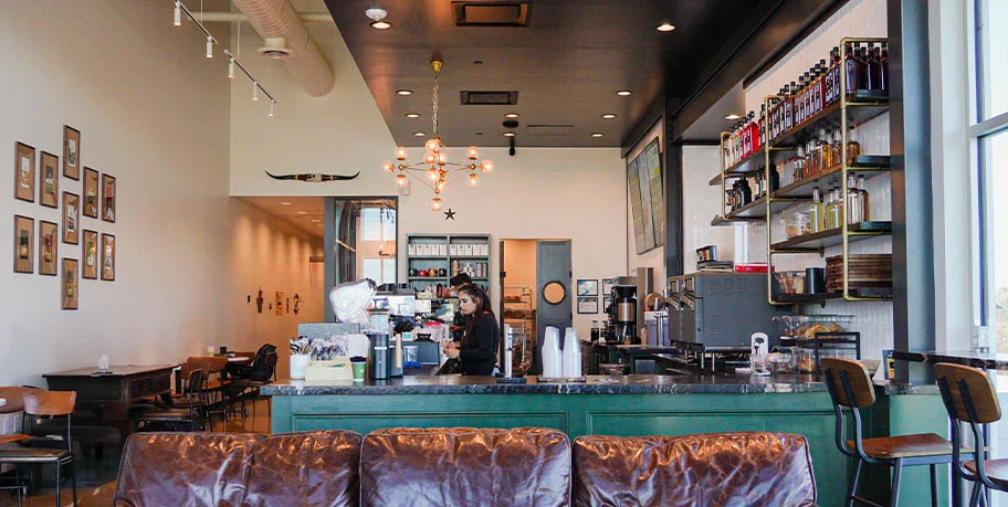 Barista preparing drinks behind the counter at First Cup Coffee Co. in Rosenberg, Texas.